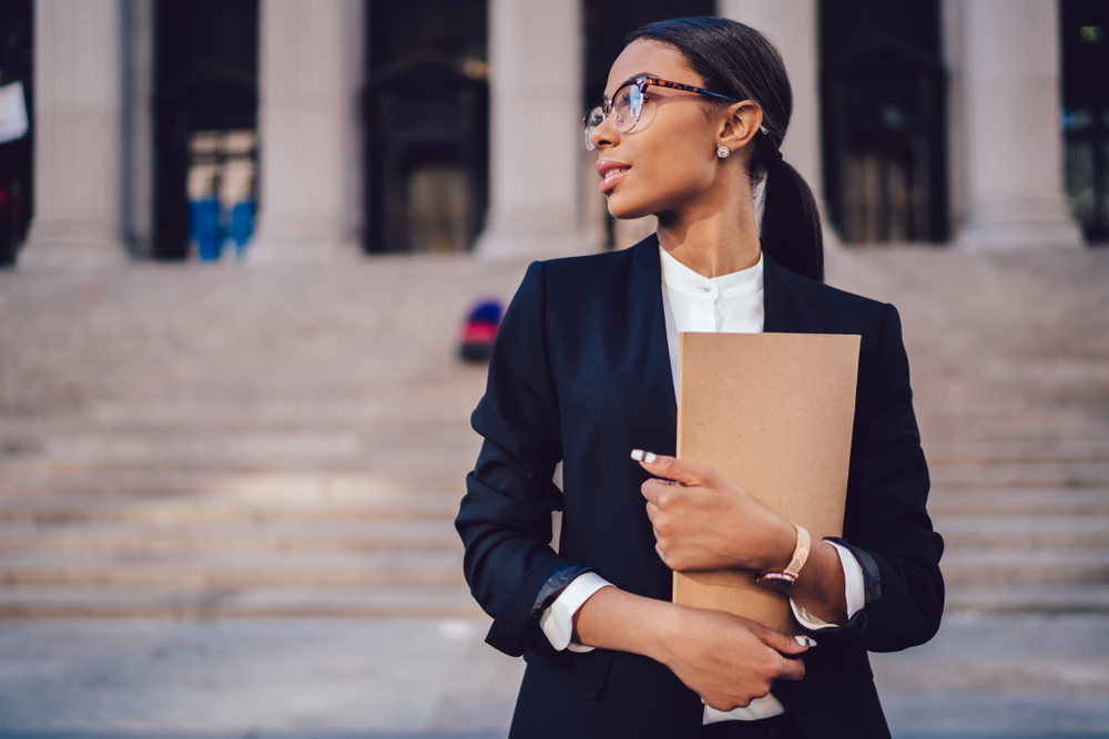 Pensive,African,American,Female,Lawyer,In,Stylish,Formal,Suit,Holding